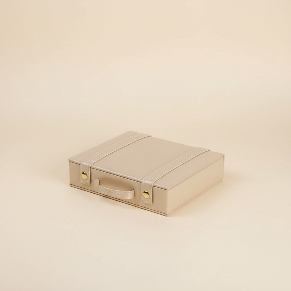 Boîte à bijoux forme malle en cuir à poignée, coloris beige