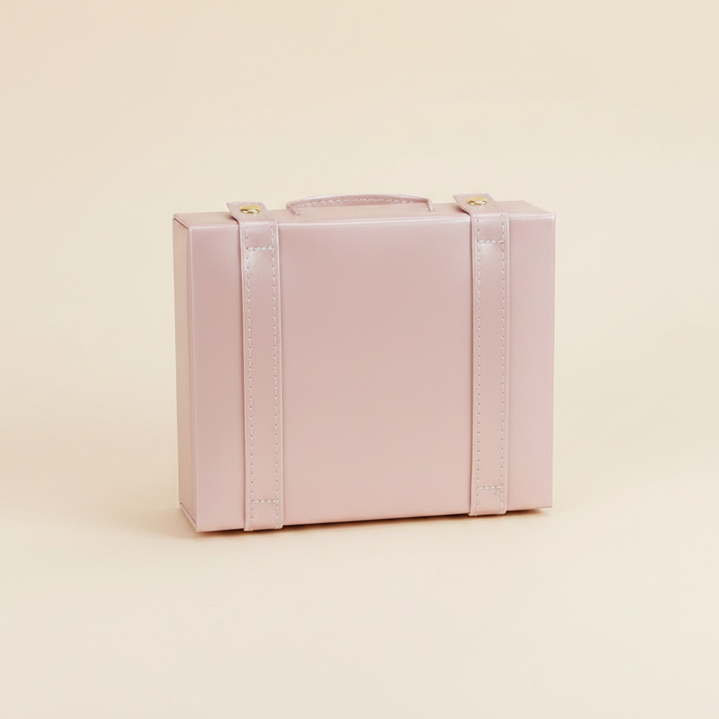 Boîte à bijoux forme malle en cuir à poignée, coloris rose